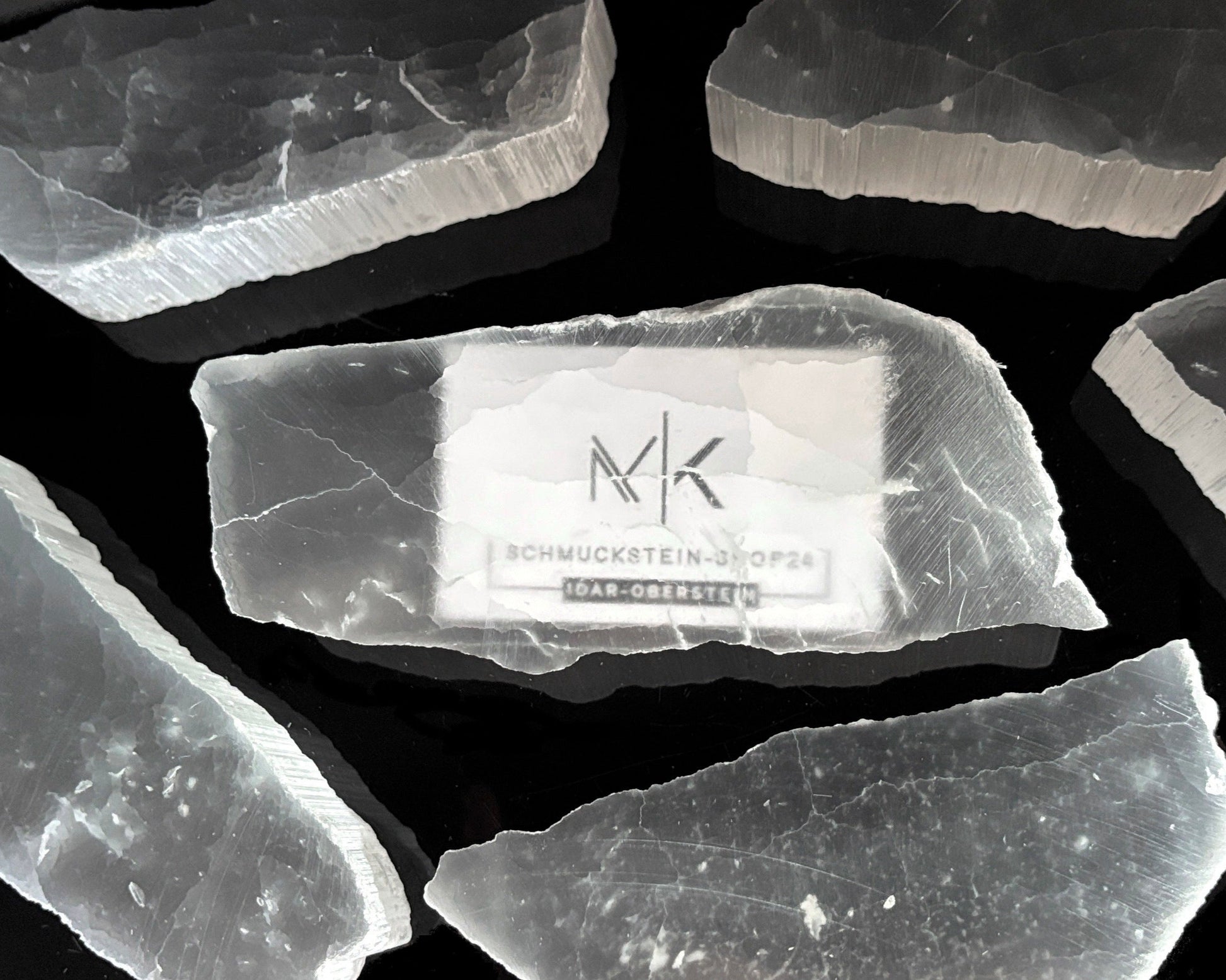 Ansicht von oben: Ulexit Kristalle mit sichtbaren Schriftzügen auf schwarzem Hintergrund