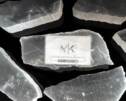 Ansicht von oben: Ulexit Kristalle mit sichtbaren Schriftzügen auf schwarzem Hintergrund